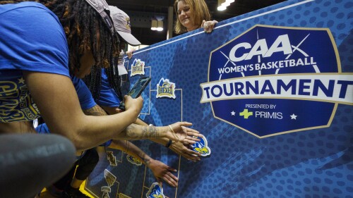 FILE - Delaware places their logo on the winning line of the tournament banner after winning the championship game against Drexel in the Colonial Athletic Association Conference NCAA college basketball tournament, Sunday, March 13, 2022, in Philadelphia. The Colonial Athletic Association has changed its name to the Coastal Athletic Association. The association of schools located in nine states along the Atlantic seaboard announced the name change on Thursday, July 20, 2023, to reflect its recent expansion, with members spanning from Massachusetts to South Carolina. (AP Photo/Chris Szagola, File)