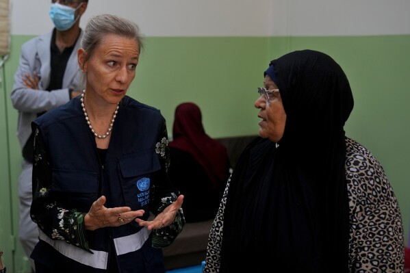 Dorothee Klaus, UNRWA's director in Lebanon, left, speaks with Munira Abu Aamsha, 63, who fled from the Palestinian refugee camp of Ein el-Hilweh, at a vocational training center run by the UNRWA in the southern town of Sebline, south of Beirut, Lebanon, Wednesday, Sept. 20, 2023. Abu Aamsha said, "I've been through more than one war and I'm not afraid for myself, but I'm afraid for my children. Now my children are living through the same thing I went through." (AP Photo/Bilal Hussein)
