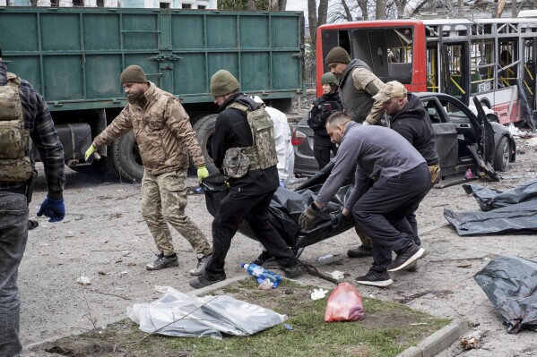 Ukrainian servicemen carry a dead body after a Russian missile strike on Sumy, Ukraine, Sunday, April 13, 2025. (AP Photo/Volodymyr Hordiienko)