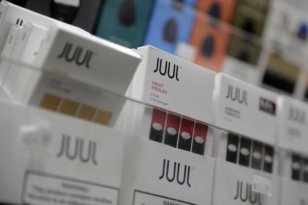 FILE - Juul products are displayed at a smoke shop in New York, on Dec. 20, 2018. Embattled vaping company Juul Labs announced layoffs Thursday, Nov. 10, 2022, as the company tries to weather growing setbacks to its electronic cigarette business, including lawsuits, government bans and increasing competition. (AP Photo/Seth Wenig, File)