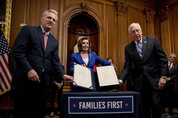 FILE - House Speaker Nancy Pelosi of Calif., center; House Minority Leader Kevin McCarthy of Calif.; left, and House Majority Leader Steny Hoyer of Md., hold up the Coronavirus Aid, Relief, and Economic Security (CARES) Act after Pelosi signed it on Capitol Hill, Friday, March 27, 2020, in Washington, before the $2.2 trillion package was signed by President Donald Trump. An Associated Press analysis published on Monday, June 12, 2023, found that fraudsters potentially stole more than $280 billion in COVID-19 relief funding; another $123 billion was wasted or misspent. Combined, the loss represents a jarring 10 percent of the total $4.2 trillion the U.S. government has so far disbursed in COVID-relief aid. (AP Photo/Andrew Harnik, File)