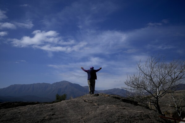FILE - Jorge Hector Roldan, better known as Larry, stands with his arms spread out, facing the Uritorco mountains in Capilla del Monte, Cordoba, Argentina, Tuesday, July 18, 2023. In the pope's homeland of Argentina, Catholics have been renouncing the faith and joining the growing ranks of the religiously unaffiliated. Commonly known as the "nones," they describe themselves as atheists, agnostics, spiritual but not religious, or simply: "nothing in particular." (AP Photo/Natacha Pisarenko, File)