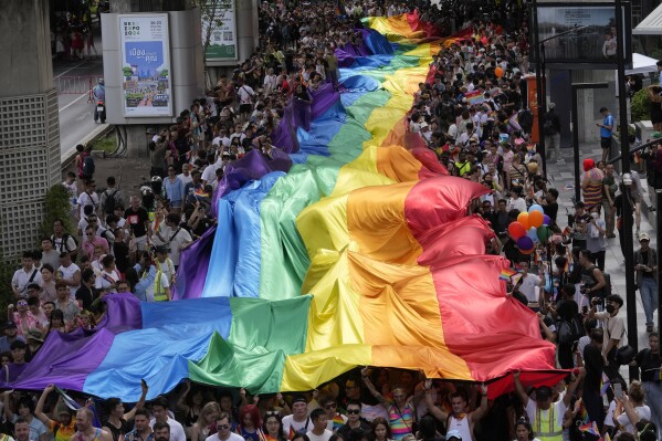 Participants hold a rainbow flag during the Pride Parade in Bangkok, Thailand, Saturday, June 1, 2024. Thailand is kicking off its celebration for the LGBTQ+ community's Pride Month with a parade on Saturday, as the country is on the course to become the first nation in Southeast Asia to legalize marriage equality. (AP Photo/Sakchai Lalit)