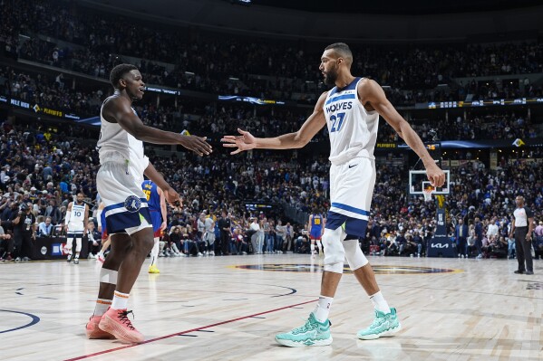 Minnesota Timberwolves guard Anthony Edwards, left, is congratulated by center Rudy Gobert as time runs out in the second half of Game 1 of an NBA basketball second-round playoff series against the Denver Nuggets Saturday, May 4, 2024, in Denver. (AP Photo/David Zalubowski)