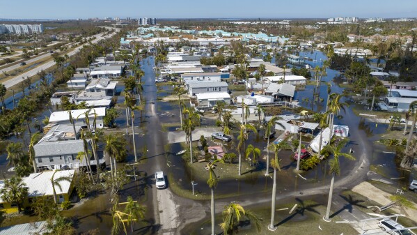 FILE - Water floods a damaged trailer park in Fort Myers, Fla., Oct. 1, 2022, after Hurricane Ian passed by the area. (AP Photo/Steve Helber, File)