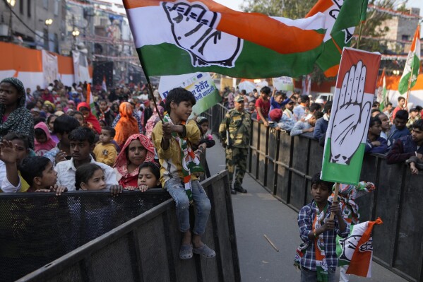 Children hold the Congress party flag during Delhi Assembly elections campaign rally in Delhi, India, Thursday, Jan. 30, 2025. (AP Photo/Channi Anand)