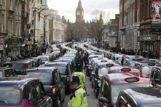 FILE - In this Wednesday, Feb. 10, 2016 file photo, London taxis block the roads during a protest in central London, concerned with unfair competition from services such as Uber. London’s transit operator says it is not renewing Uber’s license to operate in the British capital. Uber’s license expires Monday Nov. 25, 2019. (AP Photo/Frank Augstein, File)