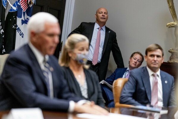 Vice President Mike Pence's Chief of Staff Marc Short, center, listens as Vice President Mike Pence, left, answers a reporters question about his former homeland security advisor Olivia Troye, who criticized President Donald Trump's handling of the pandemic, Thursday, Sept. 17, 2020, during a meeting on safety and quality for nursing homes in the Roosevelt Room of the White House in Washington. (AP Photo/Andrew Harnik)