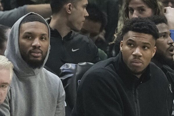 Milwaukee Bucks' Giannis Antetokounmpo and Damian Lillard watch from the bench during the first half of Game 5 of the NBA playoff basketball series Tuesday, April 30, 2024, in Milwaukee. (AP Photo/Morry Gash)
