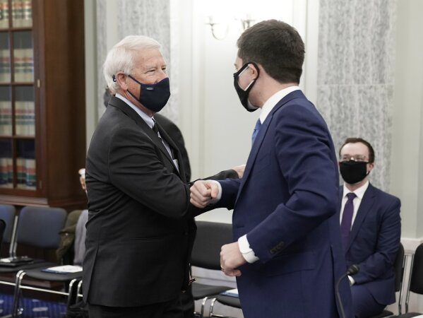 Sen. Roger Wicker, R-Miss., greets Transportation Secretary nominee Pete Buttigieg, right, before a confirmation hearing before the Senate Commerce, Science and Transportation Committee on Capitol Hill, Thursday, Jan. 21, 2021, in Washington. (Ken Cedeno/Pool via AP)