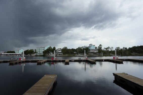 Storm clouds loom over riverfront homes in Steinhatchee, Fla., ahead of the expected arrival of Hurricane Idalia, Tuesday, Aug. 29, 2023. (AP Photo/Rebecca Blackwell)