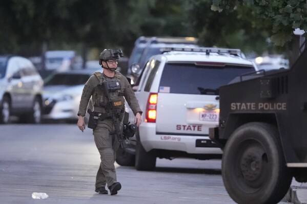 A Louisiana state police SWAT member works the scene on Iberville Street as police pursue a fugitive that escaped from a New Orleans jail, Tuesday, May 20, 2025, in New Orleans. (AP Photo/Gerald Herbert)