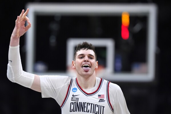 UConn center Donovan Clingan (32) celebrates after hitting a 3-pointer against Illinois during the second half of the Elite 8 college basketball game in the men's NCAA Tournament, Saturday, March 30, 2024, in Boston. (AP Photo/Steven Senne)