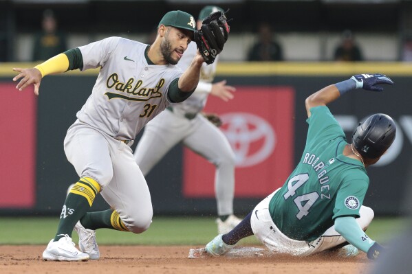 Oakland Athletics second baseman Abraham Toro (31) goes to tag Seattle Mariners' Julio Rodríguez on a steal attmpt during the sixth inning of a baseball game Saturday, May 11, 2024, in Seattle. Rodríguez was tagged out after coming off the bag. (AP Photo/Jason Redmond)