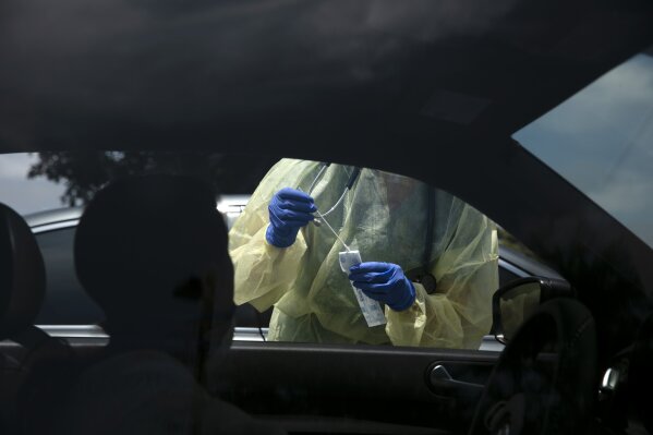 FILE - In this June 25, 2020, file photo, a physician assistant prepares to collect a nasal swab sample from a patient for COVID-19 testing at Xpress Urgent Care in Tustin, Calif. The personal protective gear that was in dangerously short supply during the initial weeks of the coronavirus crisis in the U.S. is running out again as the virus resumes its rapid spread and the number of hospitalized patients climbs. (AP Photo/Jae C. Hong, File)