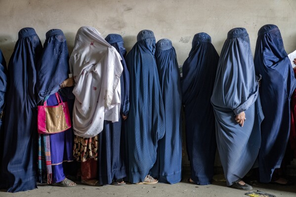 FILE - Afghan women wait to receive food rations distributed by a humanitarian aid group, in Kabul, Afghanistan, Tuesday, May 23, 2023. The mental health of Afghan women, who have suffered under harsh measures imposed by the Taliban since taking power two years ago, has deteriorated across the country, according to a joint report from three U.N. agencies released Tuesday, Sept. 19, 2023. (AP Photo/Ebrahim Noroozi, File)