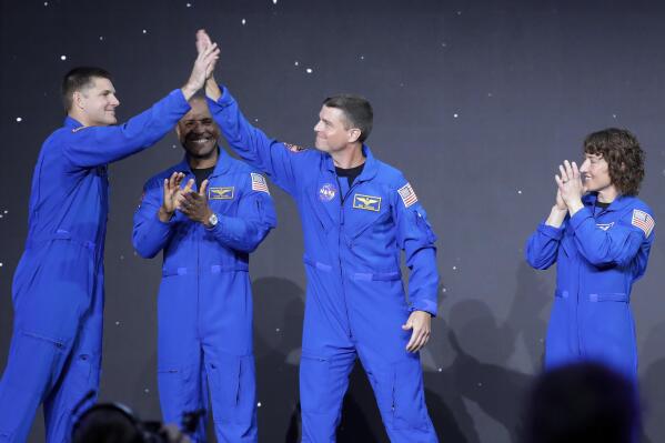 From left, Jeremy Hansen, Victor Glover, Reid Wiseman and Christina Hammock Koch, celebrate on stage as they are announced as the Artemis II crew during a NASA ceremony naming the four astronauts who will fly around the moon by the end of next year, at a ceremony held in the NASA hanger at Ellington airport Monday, April 3, 2023, in Houston. (AP Photo/Michael Wyke)