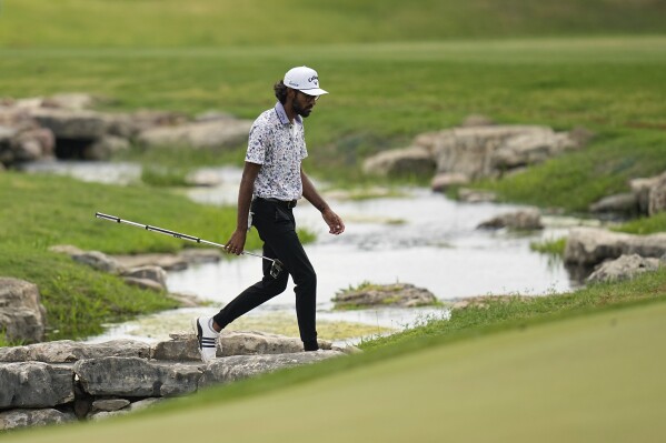 Akshay Bhatia crosses a creek as he walks to the 18th green during the third round of the Texas Open golf tournament, Saturday, April 6, 2024, in San Antonio. (AP Photo/Eric Gay)