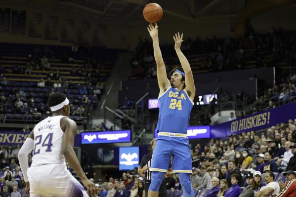 UCLA guard Jaime Jaquez Jr. shoots from the outside with Washington guard Noah Williams defending during the first half of an NCAA college basketball game, Sunday, Jan. 1, 2023, in Seattle. (AP Photo/John Froschauer)