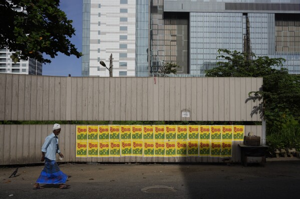A Muslim man walks past a wall pasted with election propaganda of the main opposition candidate in the upcoming presidential election in Colombo, Sri Lanka, Friday, July 26, 2023. (ĢӰԺ Photo/Eranga Jayawardena)