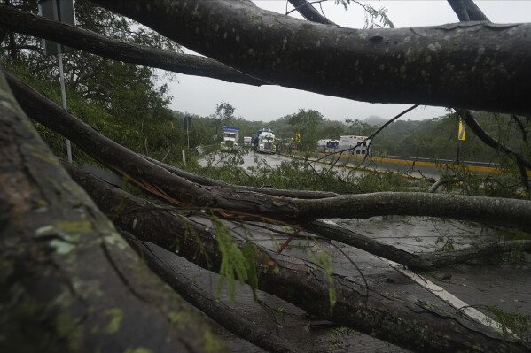 Camiones parados en una carretera bloqueada por un deslizamiento de tierra provocado por el huracán Otis cerca de Acapulco, México, el miércoles 25 de octubre de 2023. (AP Foto/Marco Ugarte)