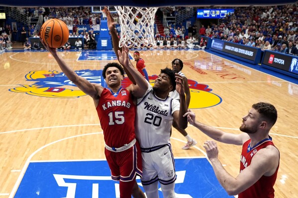 Kansas guard Kevin McCullar Jr. (15) shoots under pressure from Kansas State forward Jerrell Colbert (20) during the first half of an NCAA college basketball game Tuesday, March 5, 2024, in Lawrence, Kan. (AP Photo/Charlie Riedel)