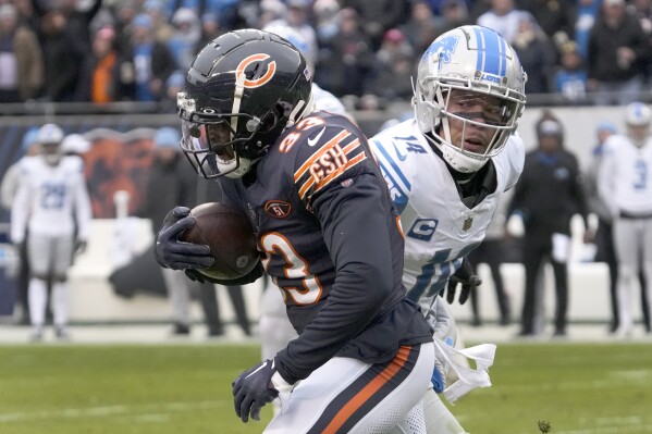 Chicago Bears cornerback Jaylon Johnson advances his interception of a Detroit Lions quarterback Jared Goff's pass as wide receiver Amon-Ra St. Brown watches during the first half of an NFL football game Sunday, Dec. 10, 2023, in Chicago. (AP Photo/Nam Y. Huh)