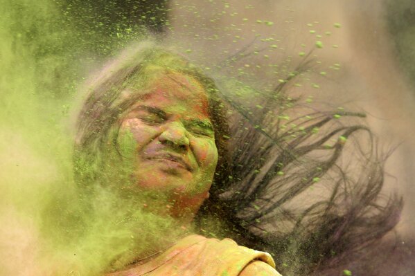 An Indian girl reacts as colored powder is thrown at her during celebration of Holi, the Hindu festival of colors, in Mumbai, India, Friday, March. 2, 2018. (AP Photo/Rajanish Kakade)