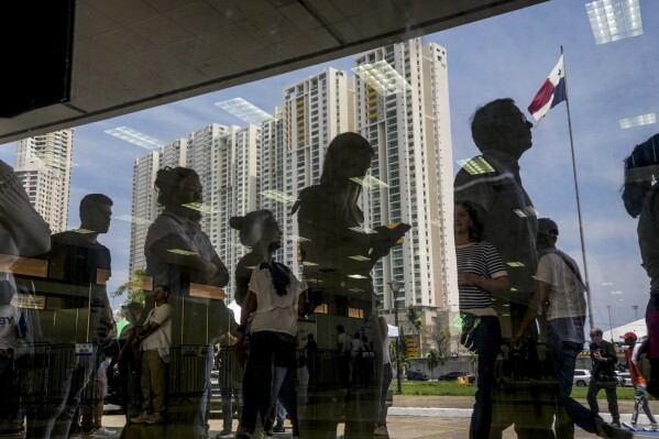 People line up to vote outside a polling station during a general election in Panama City, Sunday, May 5, 2024. (AP Photo/Matias Delacroix)