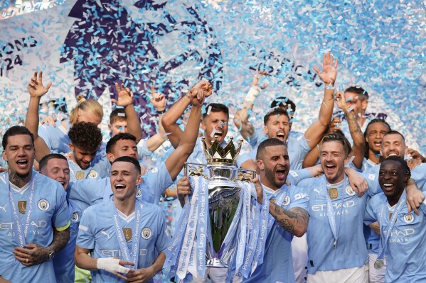 Manchester City's Kyle Walker celebrates with the Premier League trophy after the English Premier League soccer match between Manchester City and West Ham United at the Etihad Stadium in Manchester, England, Sunday, May 19, 2024. Manchester City clinched the English Premier League on Sunday after beating West Ham in their last match of the season. (AP Photo/Dave Thompson)