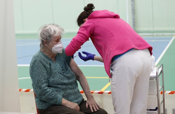 An elderly woman receives Moderna COVID-19 vaccine at a sports hall in Ricany, Czech Republic, Friday, Feb. 26, 2021. With new infections soaring due to a highly contagious coronavirus variant and hospitals filling up, one of the hardest-hit countries in the European Union is facing inevitable: a tighter lockdown. (AP Photo/Petr David Josek)