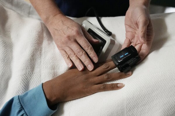 FILE - A nurse checks the vitals of a 33-year-old woman in Shreveport, La., on Oct. 9, 2021. A survey by KFF, a health policy research group, released Tuesday, Dec. 5, 2023, shows 60% of Black patients said they prepare for insults or feel they have to be careful about their appearance in order to be treated fairly by health providers. (APPhoto/Rebecca Blackwell, File)