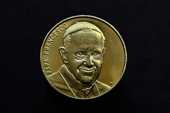 A souvenir coin depicting Pope Francis in Rome, Thursday, May 1, 2025. (AP Photo/Bernat Armangue)