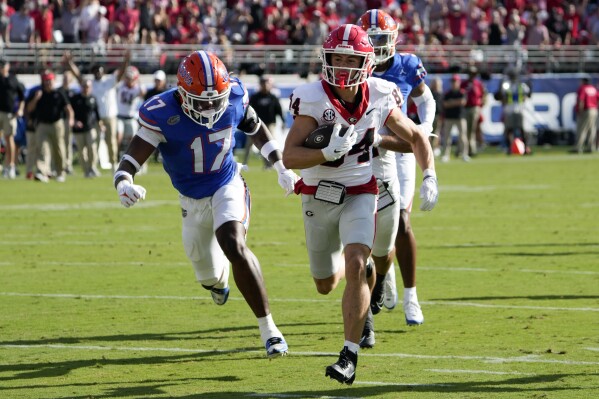 Georgia wide receiver Ladd McConkey (84) runs past Florida linebacker Scooby Williams (17) to score a touchdown on a 41-yard pass play during the first half of an NCAA college football game, Saturday, Oct. 28, 2023, in Jacksonville, Fla. (AP Photo/John Raoux)