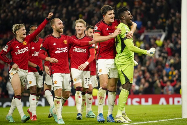 Manchester United's goalkeeper Andre Onana, right, celebrates with teammates after makes a save penalty shoot during the Champions League group A soccer match between Manchester United and Copenhagen at the Old Trafford stadium in Manchester, England, Tuesday, Oct. 24, 2023. (AP Photo/Dave Thompson)