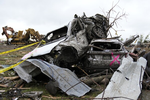 Damaged cars sit piled up next to a road after a tornado Tuesday, May 21, 2024, in Greenfield, Iowa. (AP Photo/Charlie Neibergall)