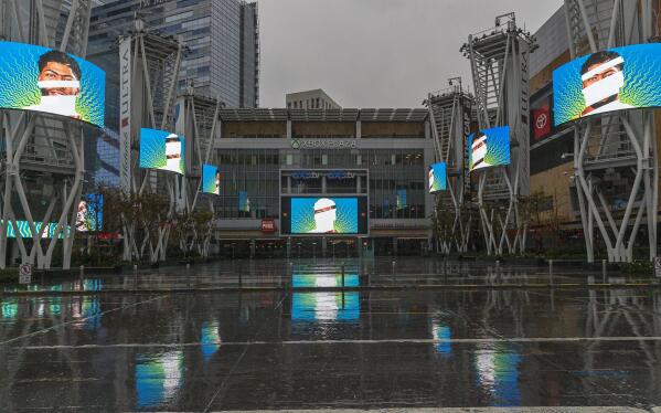 FILE - In this March 12, 2020, file photo, video screens show images of Los Angeles Lakers' Anthony Davis in a plaza across from Staples Center, home of two NBA teams, an NHL team and a WNBA team, in Los Angeles. There's a clear desire for basketball to resume but, perhaps mindful of how rushing back too quickly hurt other leagues around the world, the NBA seems to be taking very cautious baby steps back to the court. (AP Photo/Damian Dovarganes, File)