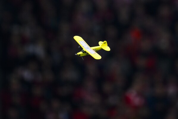 A model airplane flies inside the stadium during the Bundesliga soccer match between SC Freiburg and Eintracht Frankfurt in Freiburg, Germany, Sunday, Feb. 18, 2024. (Tom Weller/dpa via AP)