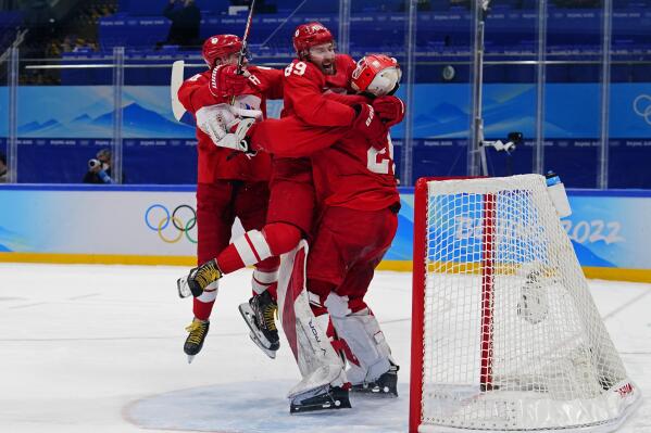 Russian Olympic Committee goalkeeper Ivan Fedotov, right, celebrates with Nikita Nesterov (89) and Yegor Yakovlev, left, after defeating Sweden in a shootout during a men's semifinal hockey game at the 2022 Winter Olympics, Friday, Feb. 18, 2022, in Beijing. (AP Photo/Matt Slocum)