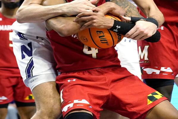 Maryland guard Fatts Russell, bottom, rebounds the ball against Northwestern forward Pete Nance during the second overtime of an NCAA college basketball game in Evanston, Ill., Wednesday, Jan. 12, 2022. Maryland won 94-87 in the second overtime. (AP Photo/Nam Y. Huh)