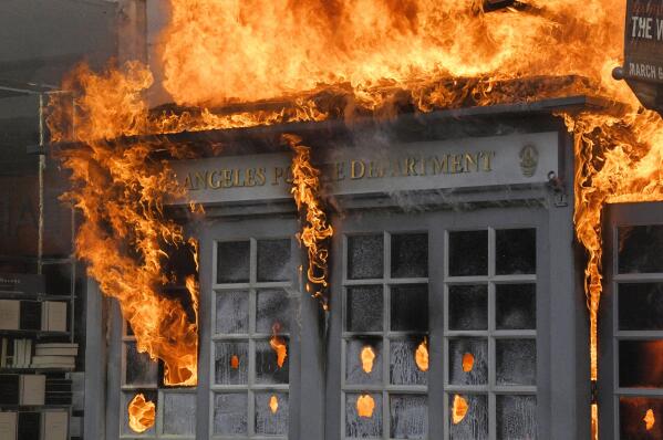 Flames rise from a Los Angeles Police Department kiosk in The Grove shopping center during a prot...