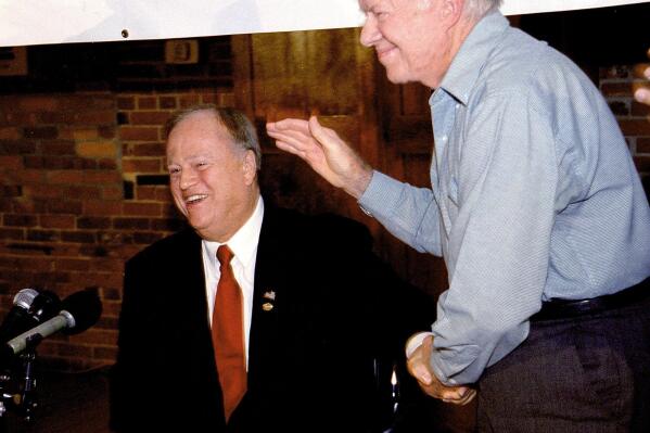 FILE - Former President Jimmy Carter, right, gives U.S. Sen. Max Cleland, D-Ga., a standing ovation during Cleland's campaign rally in Carter's rural hometown of Plains, Ga., Oct. 25, 2002. Cleland, who lost three limbs to a Vietnam War hand grenade blast yet went on to serve as a U.S. senator from Georgia, died on Tuesday, Nov. 9, 2021. He was 79. (AP Photo/Walter Petruska, file)