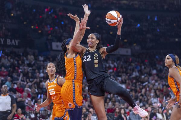 Las Vegas Aces forward A'ja Wilson (22) posts up for a shot over Connecticut Sun center Brionna Jones during the first half in Game 1 of a WNBA basketball final playoff series Sunday, Sept. 11, 2022, in Las Vegas. (AP Photo/L.E. Baskow)
