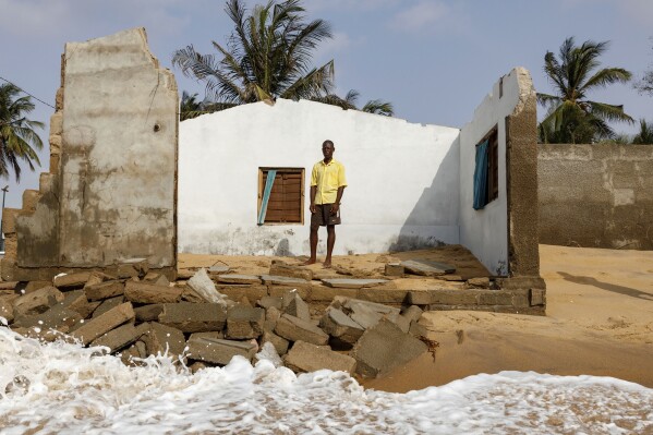 Atsu Godslove Afeli poses for a portrait in his room in his family home that was destroyed by coastal erosion in Avegadzi, Ghana, Wednesday, March 5, 2025 (AP Photo/Misper Apawu)