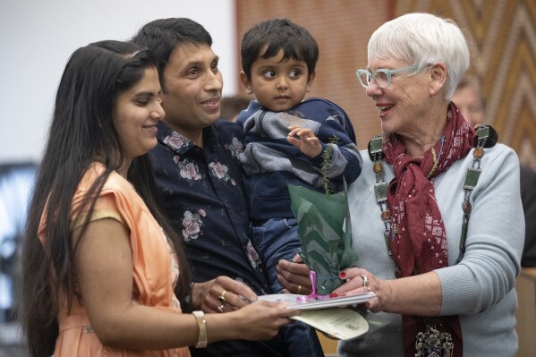 Yogeshkumar Patel, second left, holds his child as he and his wife, Divya, left, originally from India, participate in a citizenship ceremony in Rotorua, New Zealand, on July 27, 2021. New Zealand's annual net immigration has soared to a record 110,000 as a post-pandemic surge of movement continues, according to figures released Wednesday, Oct. 11, 2023. (Andrew Warner/The Daily Post via AP)
