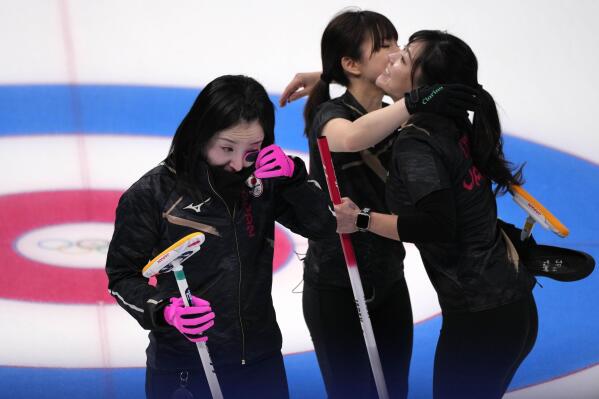 Japan's team, comfort each other, after being defeated in the women's curling match against Switzerland, at the 2022 Winter Olympics, Thursday, Feb. 17, 2022, in Beijing. (AP Photo/Nariman El-Mofty)