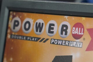 FILE - A display panel advertises tickets for a Powerball drawing at a convenience store, Nov. 7, 2022, in Renfrew, Pa. Another Powerball drawing ended with no winner Saturday night, July 15, 2023, sending the jackpot soaring to an estimated $900 million. (AP Photo/Keith Srakocic, File)