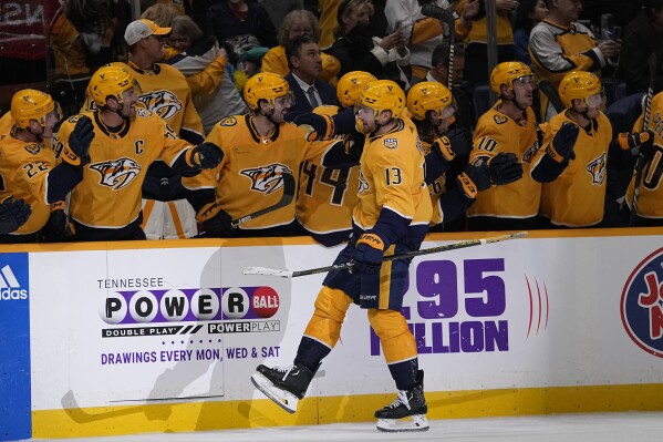 Nashville Predators center Yakov Trenin (13) celebrates a goal with teammates during the third period of an NHL hockey game against the Colorado Avalanche, Monday, Nov. 20, 2023, in Nashville, Tenn. The Predators won 4-3. (AP Photo/George Walker IV)