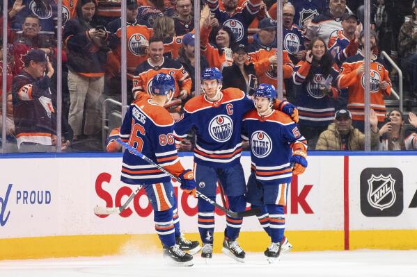 Edmonton Oilers' Philip Broberg (86), Connor McDavid (97) and Kailer Yamamoto (56) celebrate after a goal against the New York Islanders during first-period NHL hockey game action in Edmonton, Alberta, Thursday, Jan. 5, 2023. (Jason Franson/The Canadian Press via AP)
