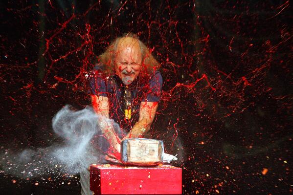 FILE - Comedian Gallagher smashes strawberry syrup and flour at the end of his performance at the Five Flags Theater in Dubuque, Iowa on In this Nov. 18, 2006. Gallagher, the smash-’em-up comedian who left a trail of laughter, anger and shattered watermelons over a decadeslong career, died Friday at his home in Palm Springs, Calif., after a brief illness. He was 76. (Jeremy Portje/Telegraph Herald via AP, File)